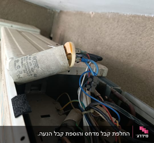 חלקים פנימיים של מזגן עם חוטים וקבלים